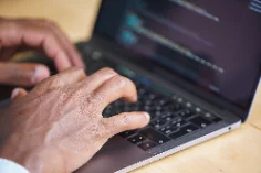 Manos escribiendo en el teclado de una notebook