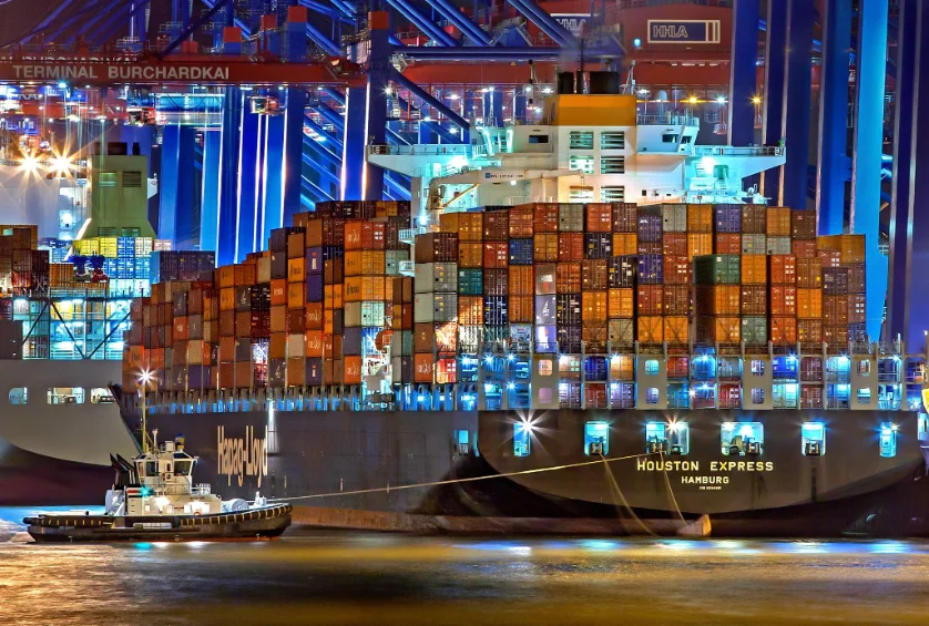Buque portacontenedores cargado en una terminal portuaria iluminada de noche